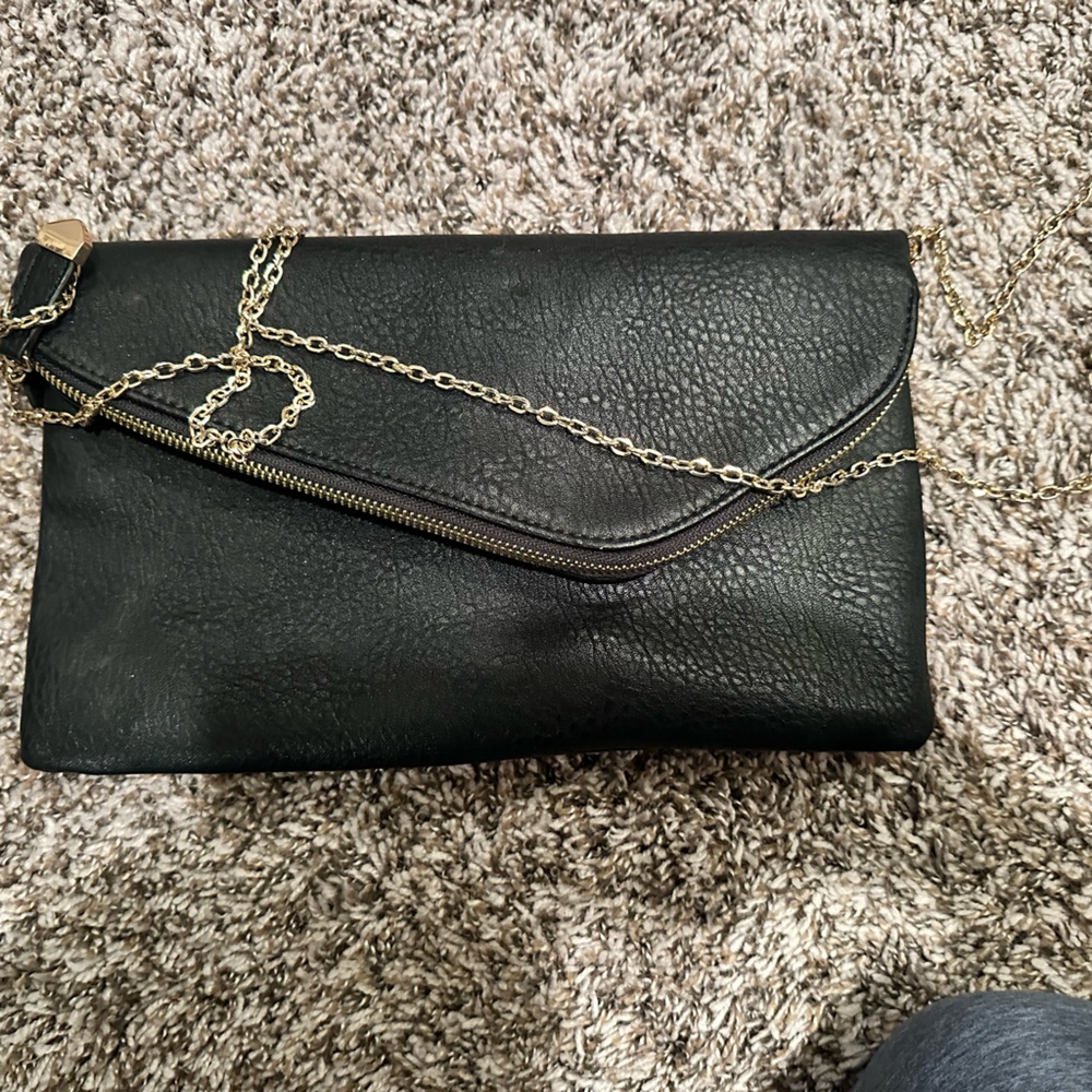 Black clutch with a gold crossbody chain
